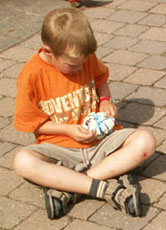 Doch vor dem Spielen muss die Plastiktüte von Alexander erst mal mit einer Kordel zum Ball zusammengeschnürt werden.