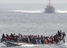 Ein Seenotrettungsschiff nähert sich einem Flüchtlingsboot auf dem Mittelmeer.