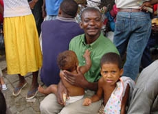 Ein haitianischer Vater mit seinen beiden Kindern - auf die Einwohner des Karibikstaates wartet eine schwere und ungewisse Zeit. Haiti ist nicht selbständig überlebensfähig und schon länger ein Spielball der Strategien der USA und der Vereinten Nationen.