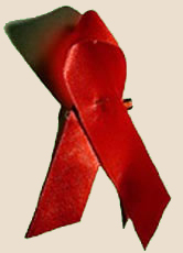 Viele Menschen stecken sich am Welt-Aids-Tag eine rote Schleife an ihre Kleidung. Sie ist ein Symbol des Mitgefühls für die Betroffenen.