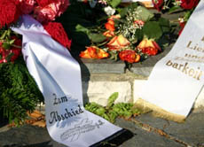 Nach der Bestattung legen Trauernde als letzten Gruß Blumen auf das Grab.