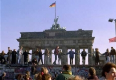 Am 9. November fiel auf Druck der Bevölkerung die Berliner Mauer. Damit wurde der Zerfall der DDR eingeleitet. Bild: Menschenmengen jubeln am Brandenburger Tor