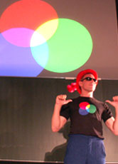 Mister Technicolor erklärt die additive Farbmischung auf seinem Bauch.